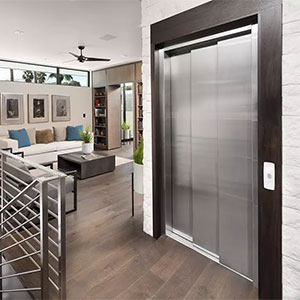 Modern Elvoron home elevator with stainless steel doors installed in a residential living room