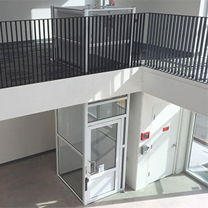 Genesis vertical platform lift with full glass enclosure providing access between floors