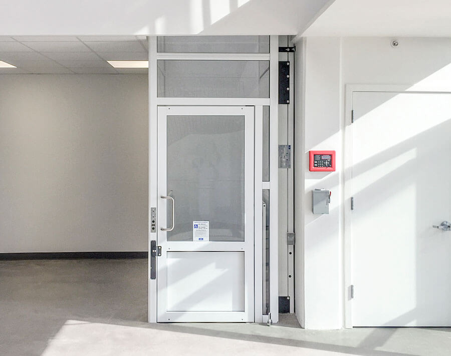 Genesis enclosure model vertical platform wheelchair lift with swinging hall door