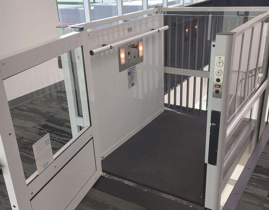 Genesis enclosure model vertical platform wheelchair lift with open swinging hall door