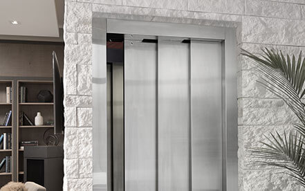 Home elevator with swinging hall door next to a staircase